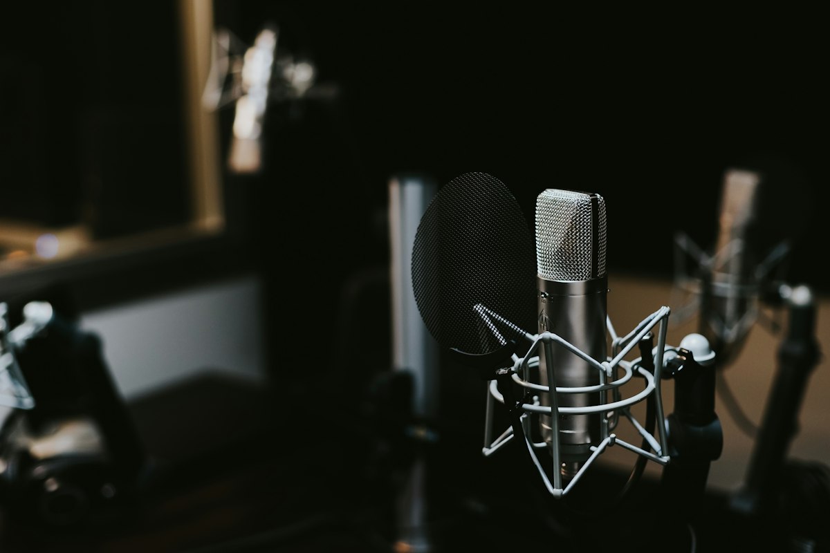 Headphones on a surface with audio waves and voice synthesis technology